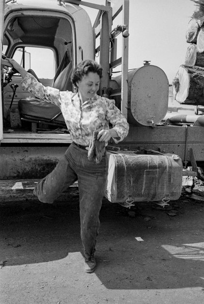 Woman truck driver Mildred Cooper steps out of the cab of her logging truck by Ted Spiegel