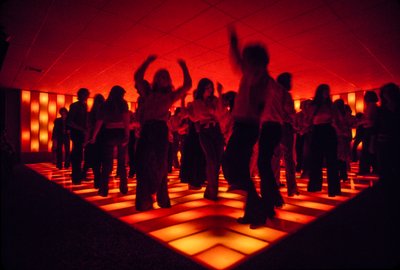 Young dancers at a nightclub dancing on an illuminated floor by Ted Spiegel