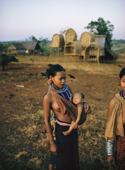 Khmer Loeu mother and her child in a sling and traditional hill tribe sarong in Phum by Thomas J. Abercrombie