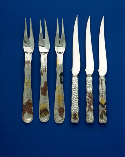 Part of a fine and rare set of 36 dessert knives and forks, the spot hammered handles inlaid with patinated copper and varicolored gold, with engraved details of various floral, animal and geometric designs, c.1880 by Tiffany and Company