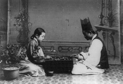 A Man and a Woman Playing a Game of Baduk or 