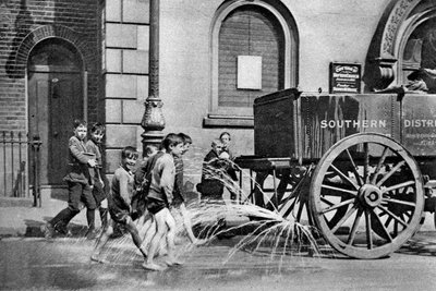 Boys following the Poplar Borough Council water cart, London, 1926-1927 by Unbekannt