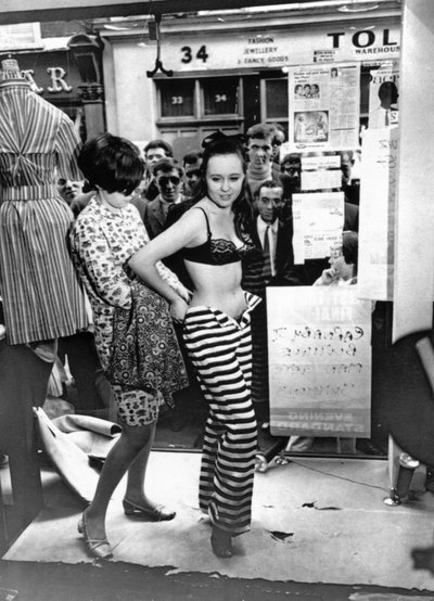 Dressing a model in the window of a boutique by Unbekannt