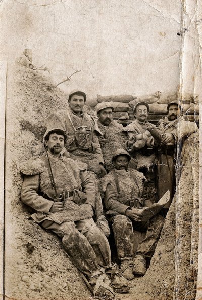 First World War (1914-1918): Hairy soldiers in winter dress in a trench in 1916-1917. They wear sheepskin jackets and a gas mask. by Unbekannt