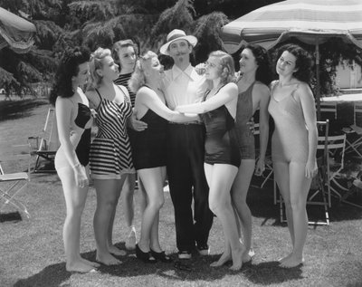 Hollywood, California: c.1935 Seven young women in bathing suits vie for the attentions of a single man by Unbekannt