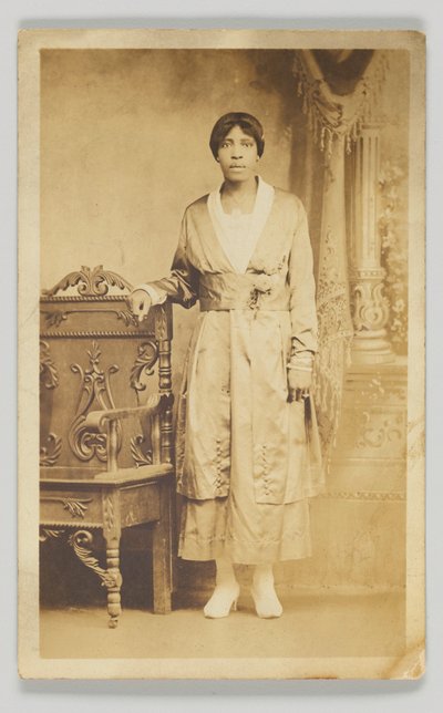 Photographic Postcard of a Woman Standing Next to a Wooden Chair, 1904-1918 by Unbekannt