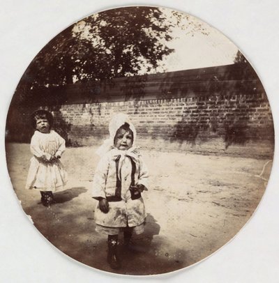Two small children walking alongside a wall, c 1890 by Unbekannt