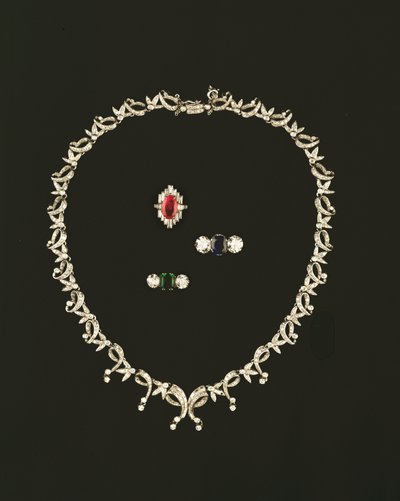 Art Deco scroll and leaf design necklace; ruby and diamond baguette cluster ring; sapphire and diamond three stone ring; emerald and diamond three stone ring by Unbekannt Unbekannt