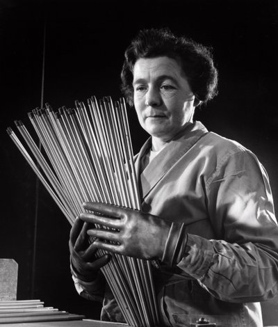 A female employee with rods of carbon electrodes used by arc welders by Unbekannt
