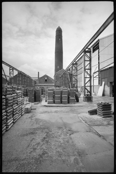 A general view of the Elswick Shot Tower, demolished 1968-69, used for creating lead shots, with a yard with palettes in the foreground, c.1955-69 by Unbekannter Künstler