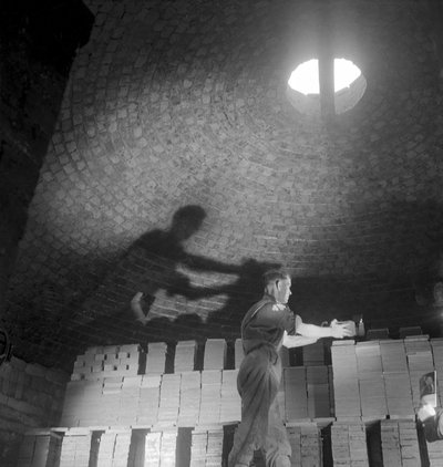 A kiln worker stacks tiles for firing, Wheatley Quarries by Unbekannt