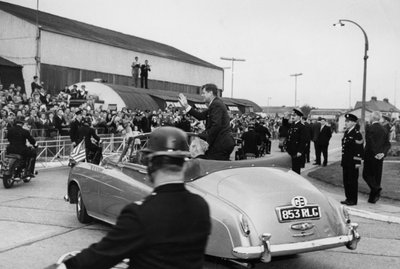After inspecting a Naval Guard of Honour at London Airport, President Kennedy and Mr Macmillan drive off in an open car by Unbekannt