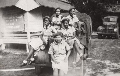 Five members of the West Indies Auxiliary Territorial Service sitting on a military vehicle by Unbekannt