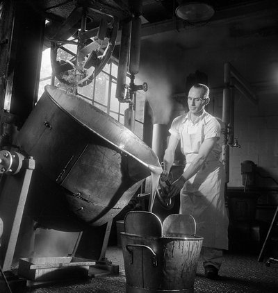 Man pouring a large vat of boiling hot toffee, Caley