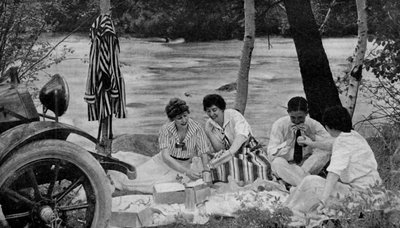 North America. Picnic party attack the luncheon basket during a motor trip to the Ozark mountains. 1920 by Unbekannt