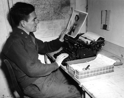 Second World War: Mutzig, France, 1 December 1944: Corporal Flanerty chronicler of the Beachead News looks at a pin-up photograph that he publishes in the next issue of the newspaper by Unbekannt