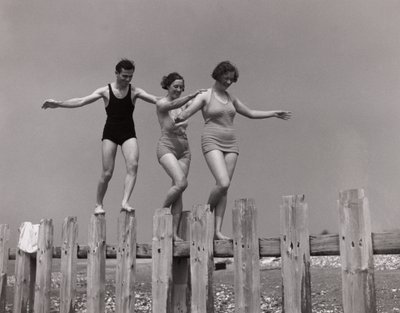 Two women and a man walking along a groyne, c 1930s by Unbekannt