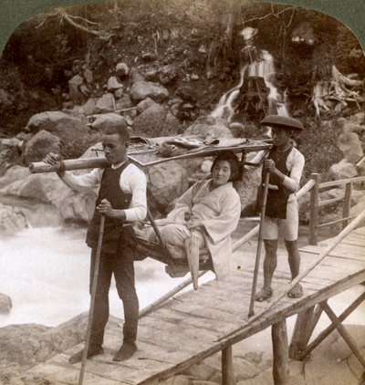 Japanese woman in a yamakago mountain chair crossing the torrential Daiya river near Nikko, Japan by Underwood and Underwood