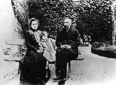 Pierre (1859-1906) and Marie Curie (1867-1934) sitting on a bench in a garden by Unknown photographer