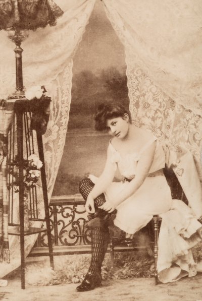 Portrait of a Young Woman in Intimate Apparel, Seated as She Laces Her Shoe by Unknown photographer