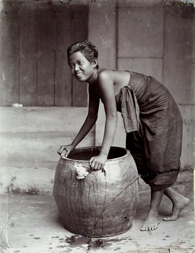 Young smiling Thai woman, pushing a large container by Unknown photographer