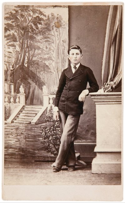 Studio portrait of young man in front of painted background of stairs and garden by William Bentley