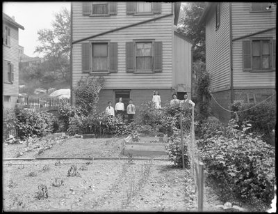 Family poses beside their backyard vegetable garden, Inwood, New York, c.1910 by William Davis Hassler