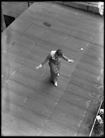 Girl stenographer on roof with arms spread as if taking a bow, August 22, 1914 by William Davis Hassler