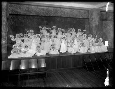 Group of little girls posed on a small stage holding fans, probably the Roman Catholic Orphan Asylum, Kingsbridge, Bronx, c.1911 by William Davis Hassler