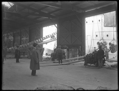 Interior Warehouse on Dock, Portable Electric Winches Being Used to Unload Ship, 31st Street, Brooklyn, 1912 by William Davis Hassler