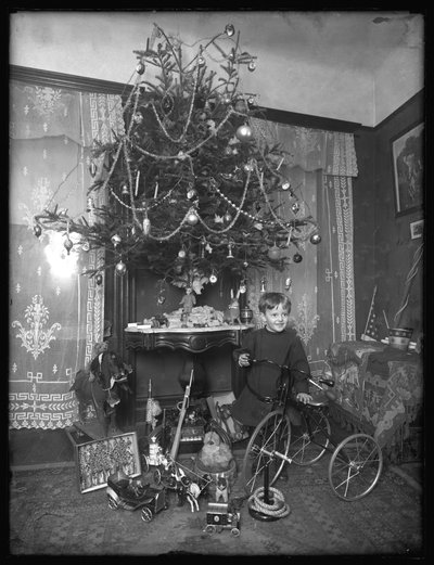 Seymour boy posed with tricycle beside Christmas tree in parlor, Christmas 1912 by William Davis Hassler
