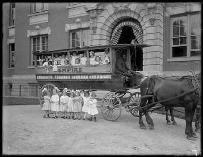 Small Girls Pose in and in Front of a Horse-Drawn Wagon, in Front of an Unidentified Building, Probably the Roman Catholic Orphan Asylum, Kingsbridge, Bronx, c.1910 by William Davis Hassler
