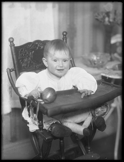 Unidentified infant seated in a high chair, 1915-16 by William Davis Hassler