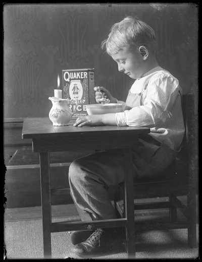 William Gray Hassler Seated at a Small Table Eating a Bowl of Quaker Puffed Rice Cereal, c.1912 by William Davis Hassler