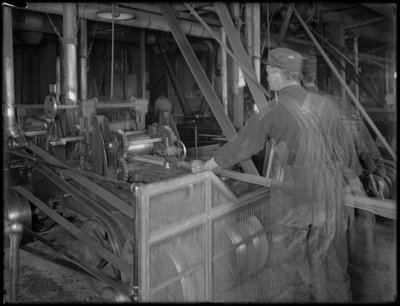 Worker feeding lumber into a planer, Oneida, New York, April 3, 1916 by William Davis Hassler