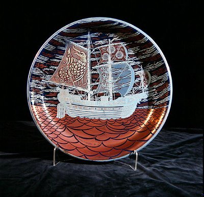 Charger with silver lustre, with a galleon sailing on a red lustre sea by William de Morgan