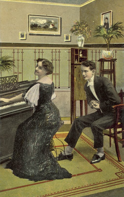 Young man admiring pretty girl playing the piano by American School