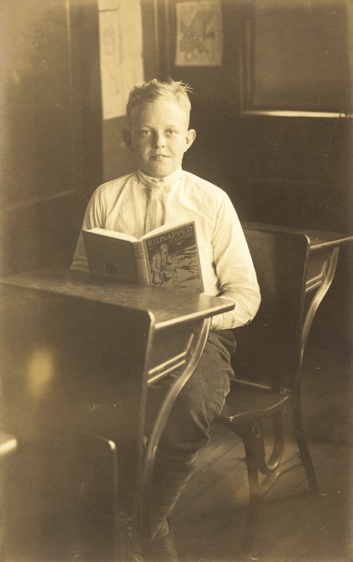 Boy reading Kidnapped by American Photographer