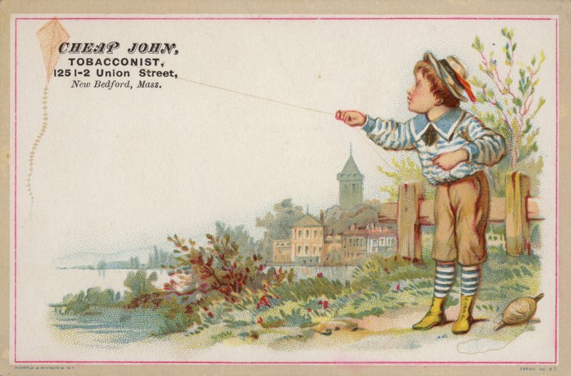 Boy flying kite next to lake by American School