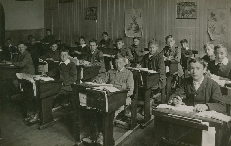 Male Pupils Sitting Behind Their Desks During a Lesson at School by English Photographer