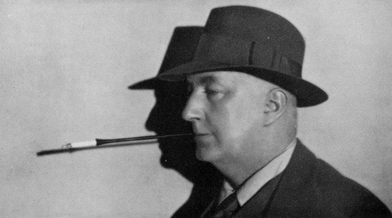 Portrait of Edgar Wallace, wearing hat and smoking cigarette in holder by English Photographer