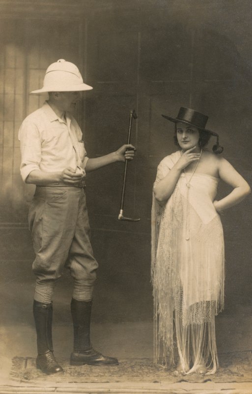 Portrait of a man dressed for riding and a woman wearing a hat and a dress by English Photographer