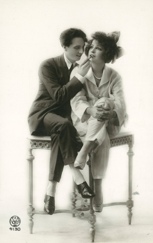 Androgynous Man in Suit Applying Lipstick to Lips of Girl in Pajamas by French Photographer