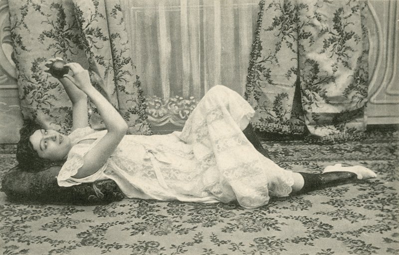 Girl, lying on the floor, holding a ball above her head by French Photographer