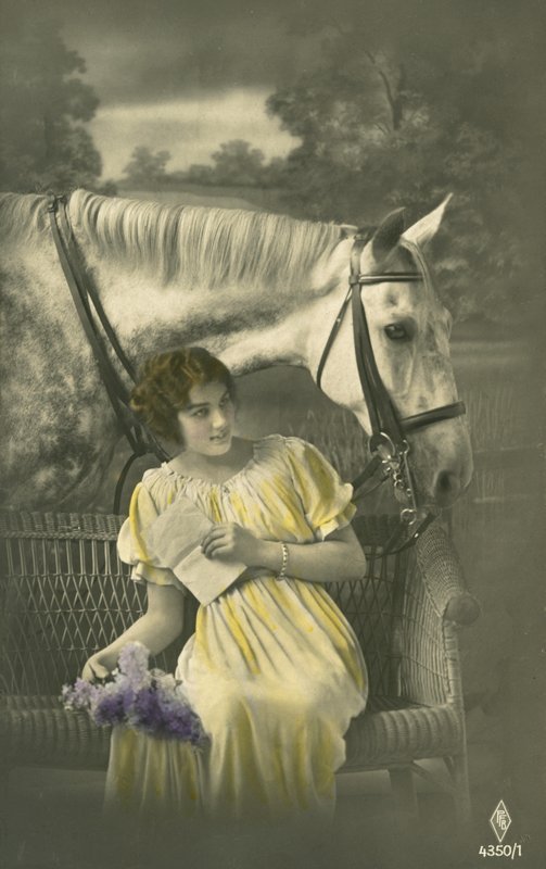 Girl sitting on sofa with white horse behind by French Photographer