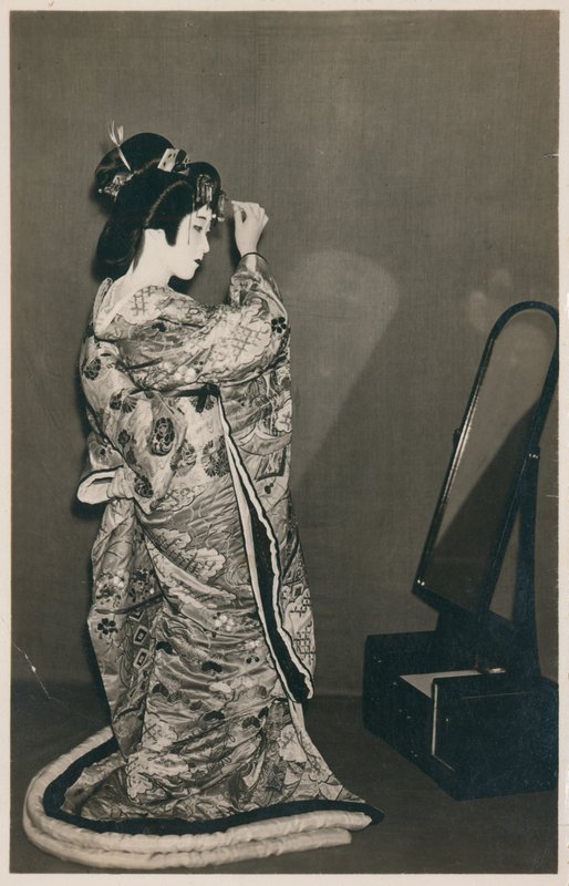 A woman dressed in a kimono by Japanese Photographer
