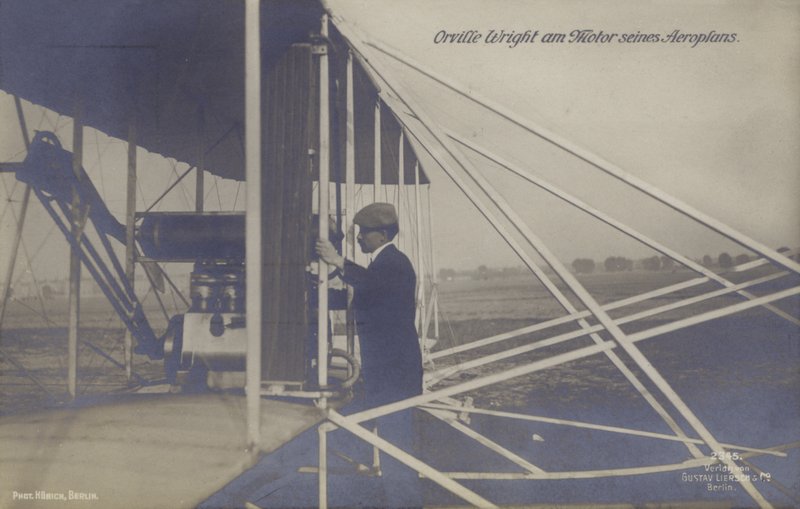 American aviator Orville Wright inspecting the engine of his aeroplane by Photographer German