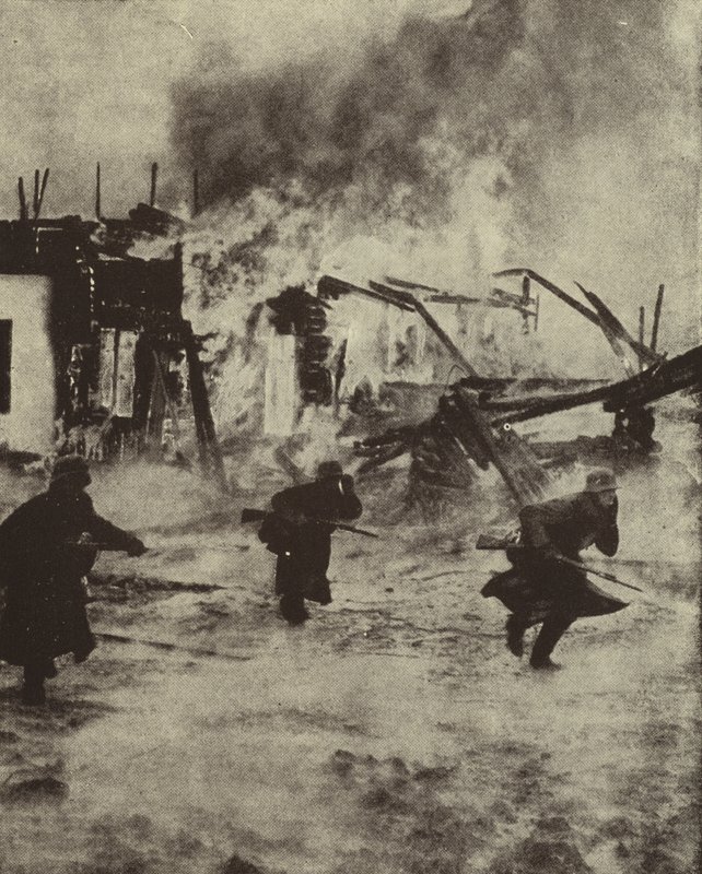 German soldiers advancing through the burning ruins of Rotterdam after its bombing by the Luftwaffe, World War II, May 1940 by Photographer German