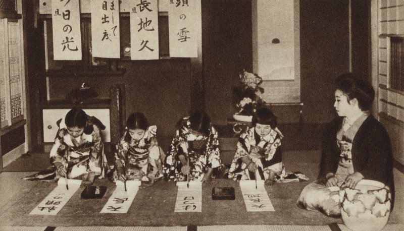 Japanese schoolgirls writing with brushes in a kindergarten class by Photographer Japanese