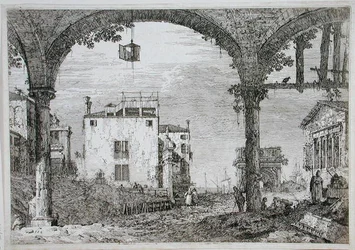 View through an arcade towards coastal buildings